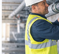 Engineer installing sprinkler pipework on site